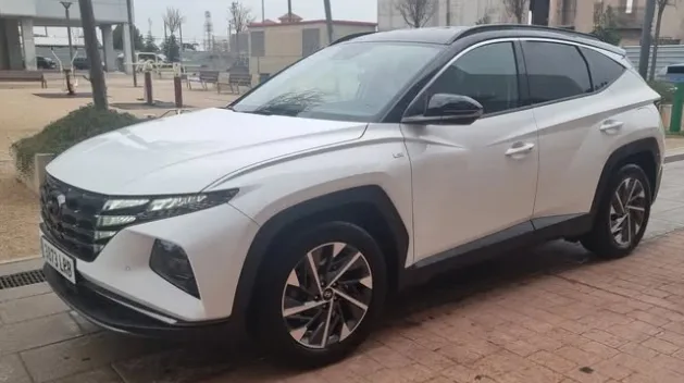 A white Hyundai Tucson parked on a city street in Marbella, featuring its modern SUV design, sharp LED headlights, bold geometric body lines, and stylish alloy wheels. This spacious and comfortable crossover is ideal for travelers looking to rent a Hyundai Tucson in Marbella, offering advanced technology, strong performance, and plenty of room for exploring the Costa del Sol. The urban setting highlights its premium look and makes it appealing for anyone searching to rent a car in Marbella.