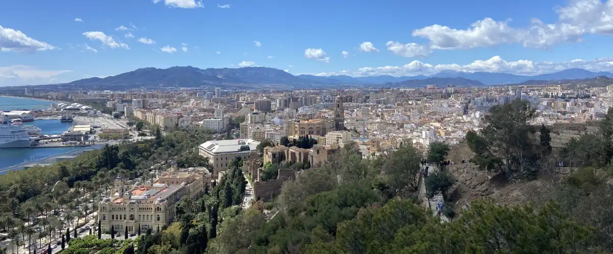 Panoramic view of Málaga city from Gibralfaro Castle showing the cathedral, port, Mediterranean Sea and surrounding mountains – starting point for the scenic A-7 drive to Marbella