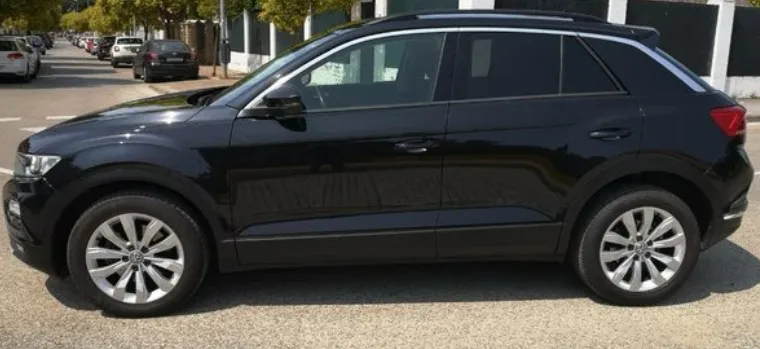 A black Volkswagen T-Roc parked on a sunny street in Marbella, highlighting its stylish compact SUV design, sleek body lines, modern alloy wheels, and sporty stance. This popular crossover is ideal for travelers looking to rent a Volkswagen T-Roc in Marbella, offering comfort, versatility, and a premium driving experience along the Costa del Sol. The bright surroundings emphasize its appeal for anyone searching to rent a car in Marbella.